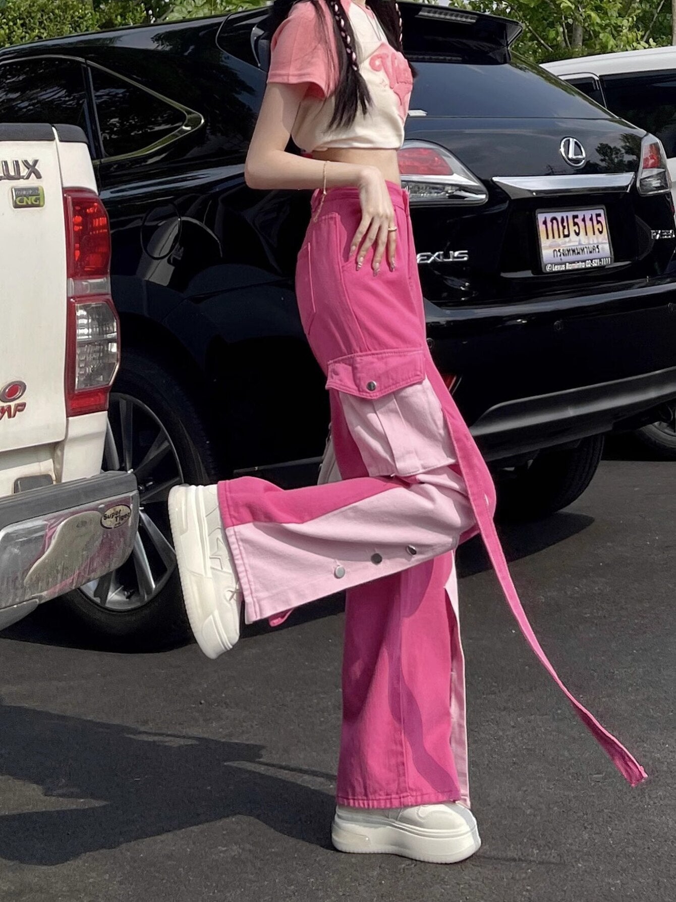 a Barbiecore girl wearing a pink and white Barbiecore crop top and a white Barbiecore bag and Barbie patchwork cargo pants