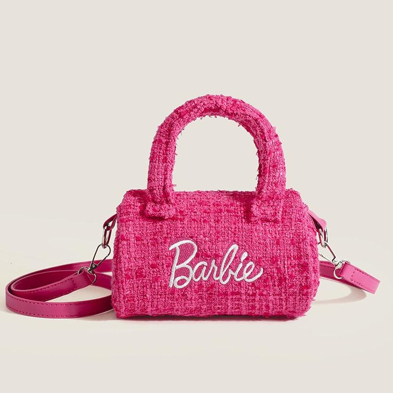 a girl holding a pink aesthetic bag with barbie written on it