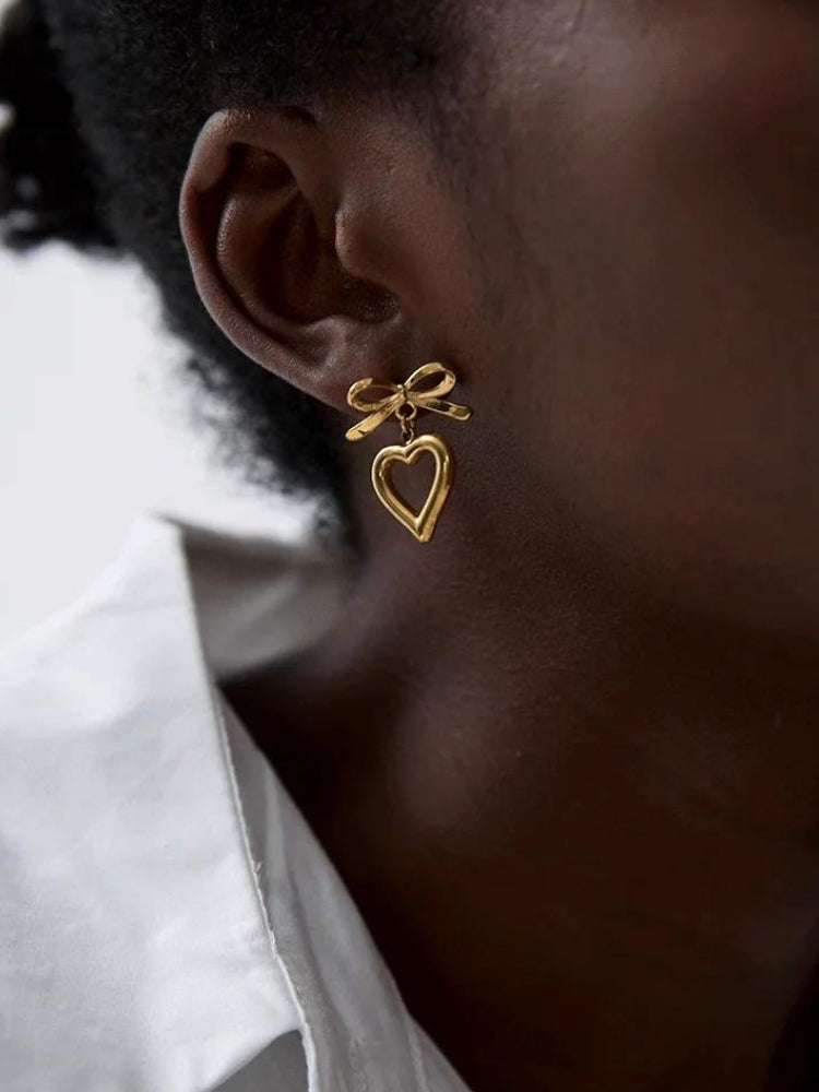 Close-up of a woman wearing a gold bow hear earring
