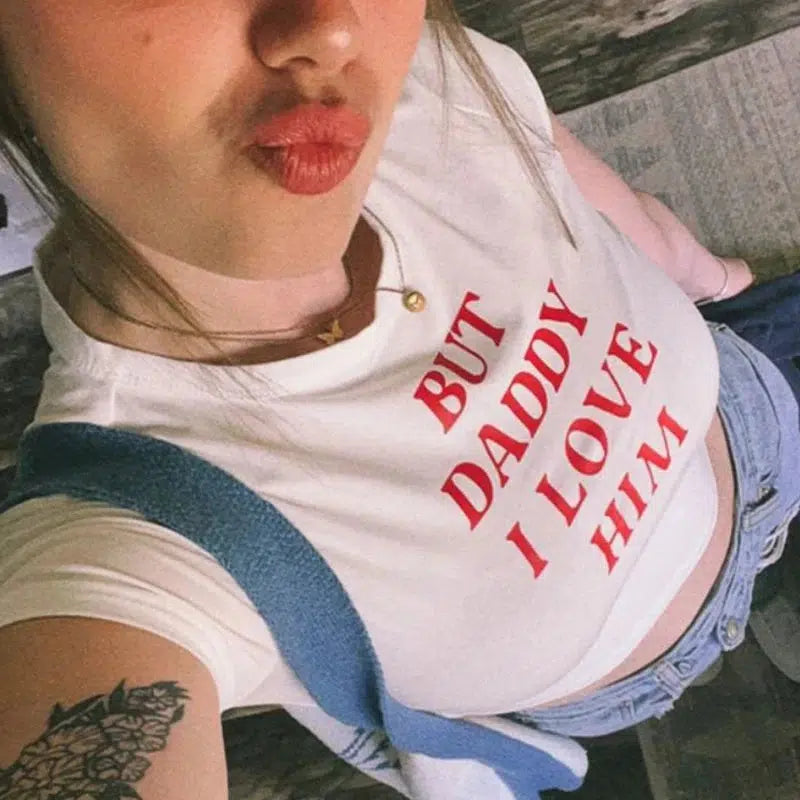 a girl is wearing a but daddy i love him baby tee in white for acubi fashion
