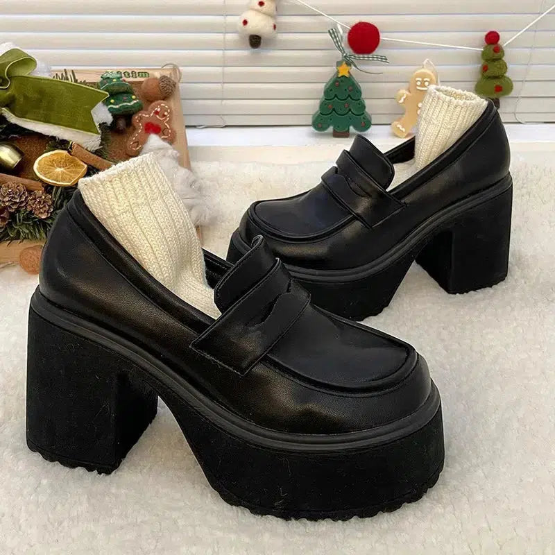 A pair of chunky platform high heel loafer shoes in black, featuring a sleek design with a high block heel and thick platform sole.