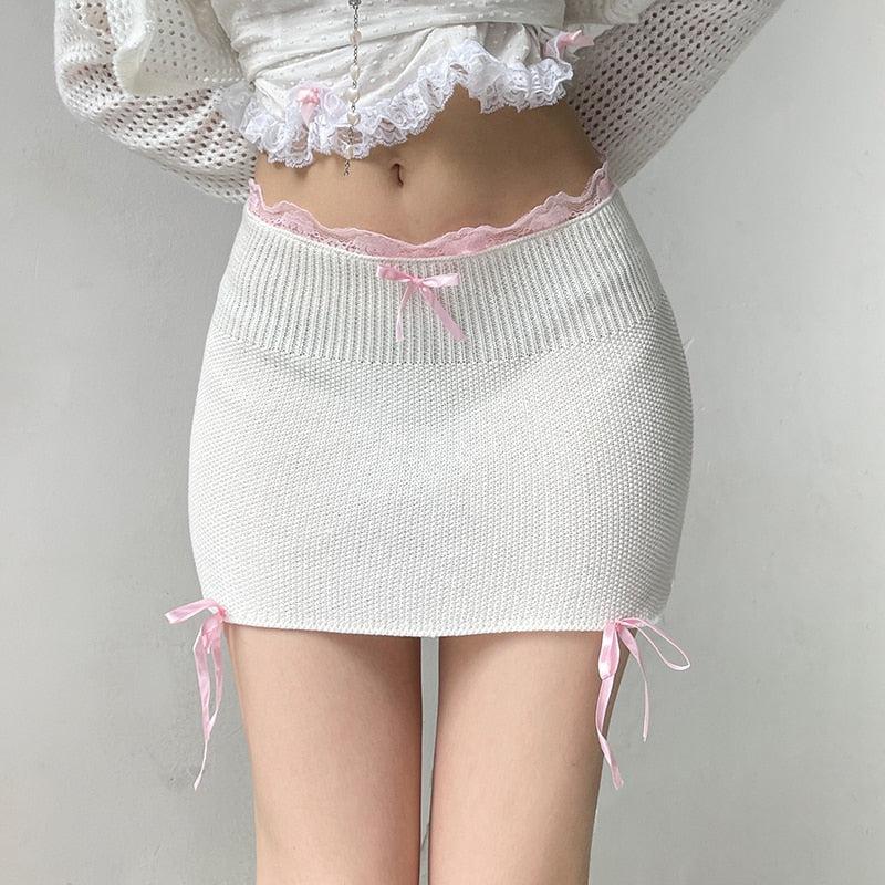 a girl wearing a white coquette aesthetic pink ribbons mini skirt and a lace detailed crop top