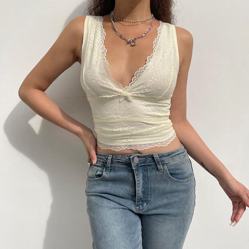 a girl wearing a white coquette aesthetic v-neck lace crop top and jeans and a silver necklace