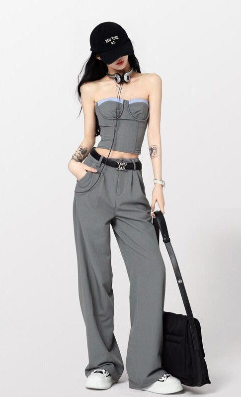 a girl wearing corset top and wide leg pants two piece set and a buckle belt and a black hat and an aesthetic bag