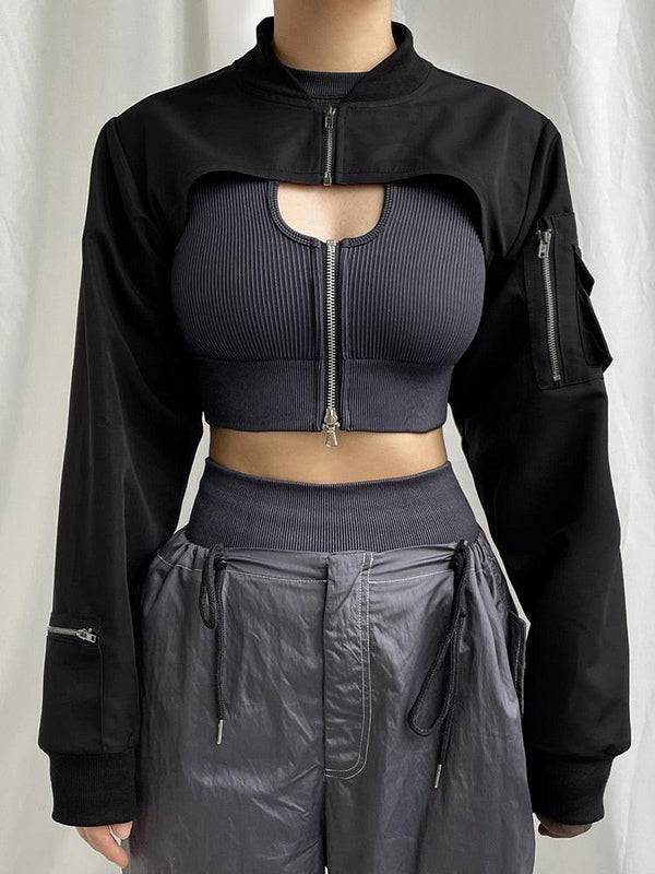 une fille porte une veste boléro esthétique cyberpunk noire et elle porte aussi un crop top gris et un pantalon