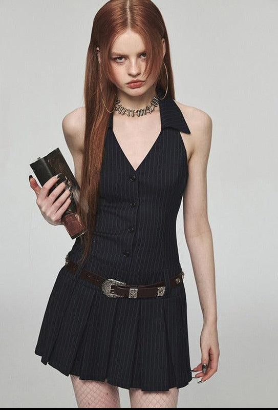 une fille porte une robe mini halter light academia noire, un mini sac à main noir, une ceinture et une jupe