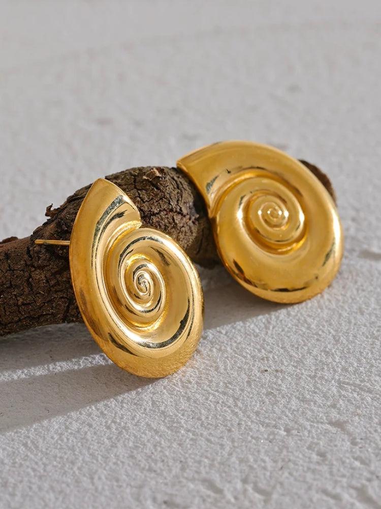 Close-up of a woman wearing a gold sea shell-inspired spiral earring from the Gold Sea Shell Necklace & Earrings set