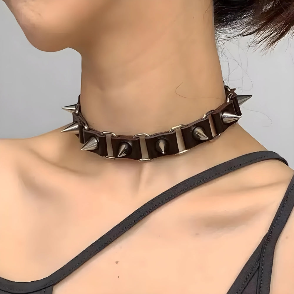 a girl is wearing a goth barbed choker necklace in black and silver