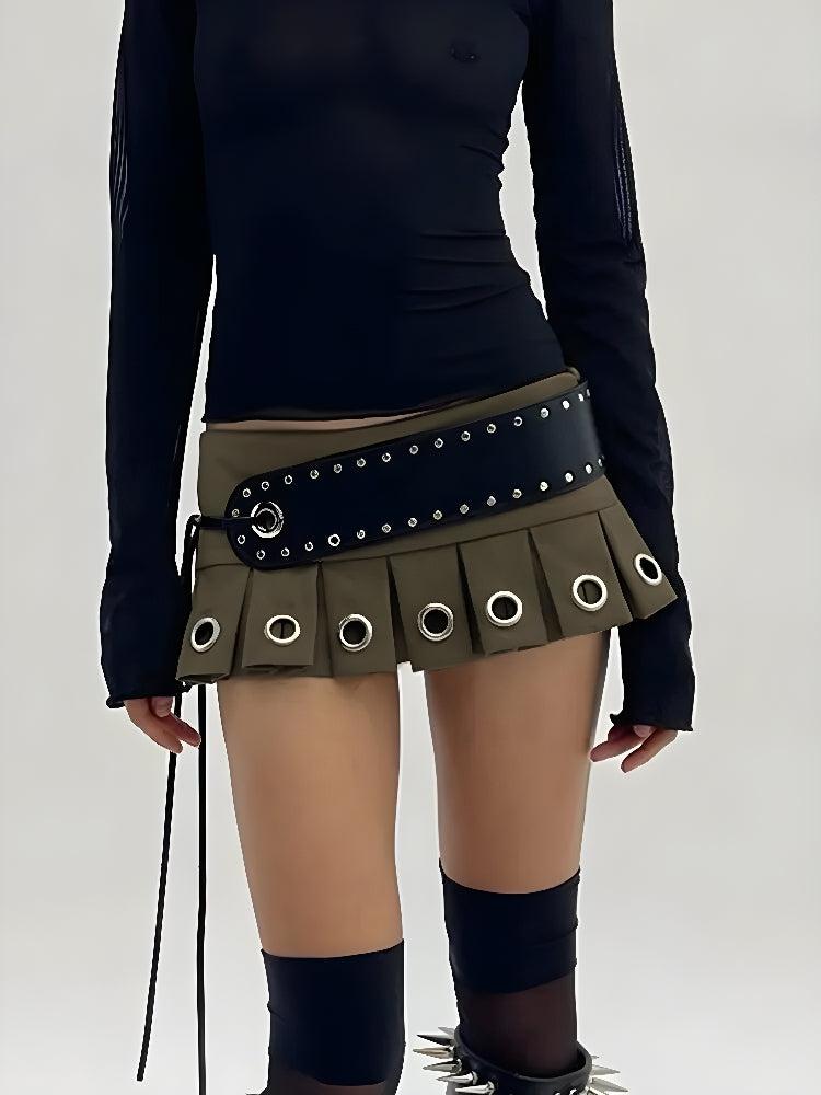 una chica de estética grunge lleva una minifalda extra con cinturón grunge en verde oscuro y una blusa negra y calcetines negros hasta el muslo