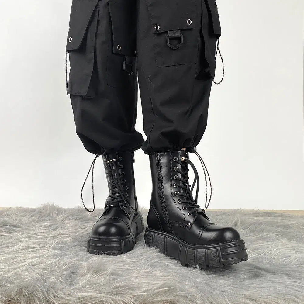 Una chica lleva botas de combate góticas militares y pantalones cargo en negro.