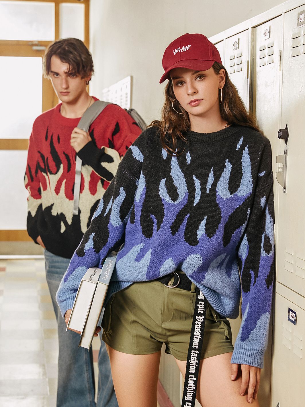 an elevated indie boy and a girl wearing indie flame knitted sweaters in blue, red, and black and they are at school