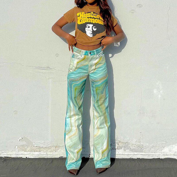 une fille porte un pantalon indie tie dye et un t-shirt marron avec une tête d'homme imprimée