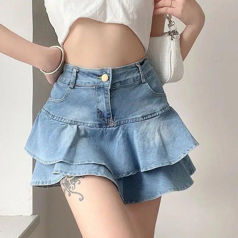 a girl is wearing a layered ruffled denim mini skirt and a white crop top and a white mini bag for acubi fashion