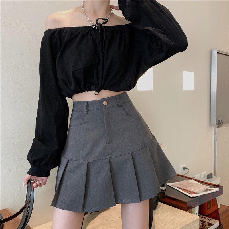 A pleated mini skirt featuring a stylish side slit and in-built shorts, perfect for a chic college look.