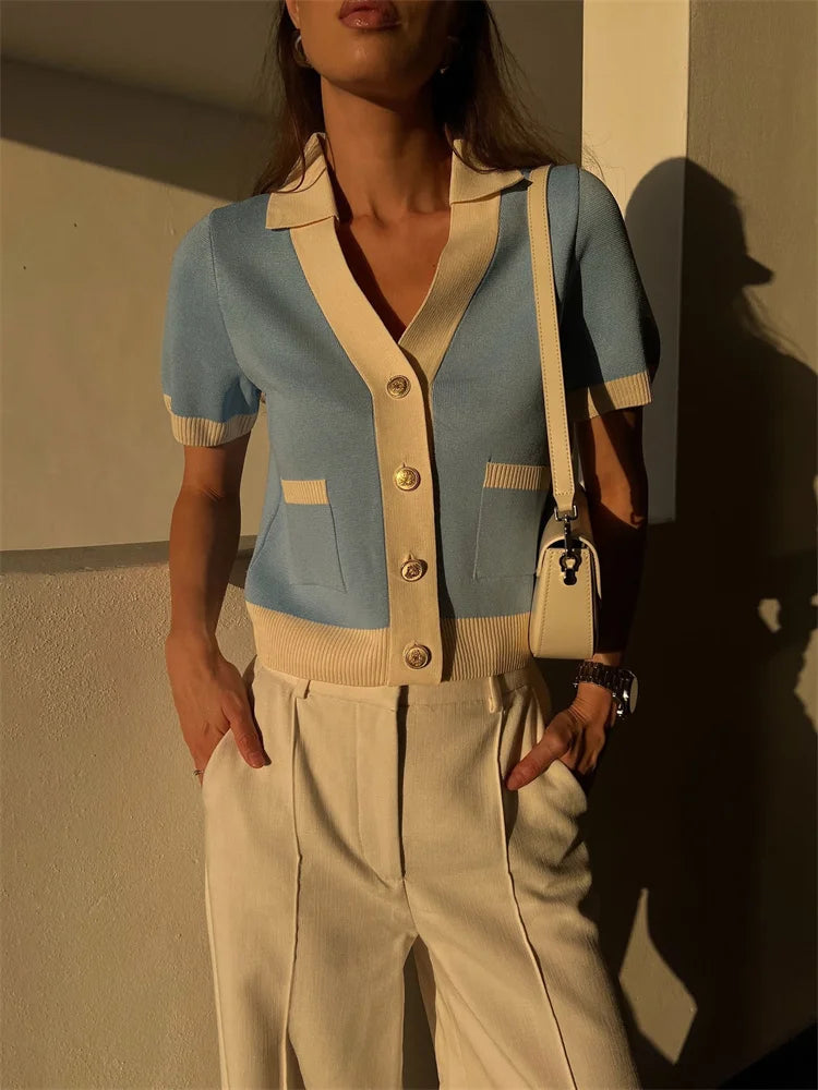 a girl is wearing a pastel blue preppy cardigan with contrast trim and button-up front