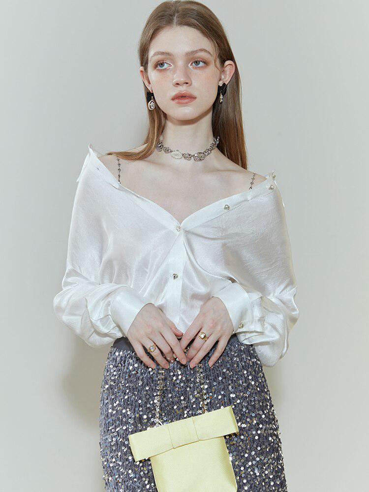 an old money aesthetic girl is wearing a pure design white satin blouse and holding her yellow mini bag, she is also wearing a shiny blue skirt and silver accessories such as a necklace, rings, and earrings