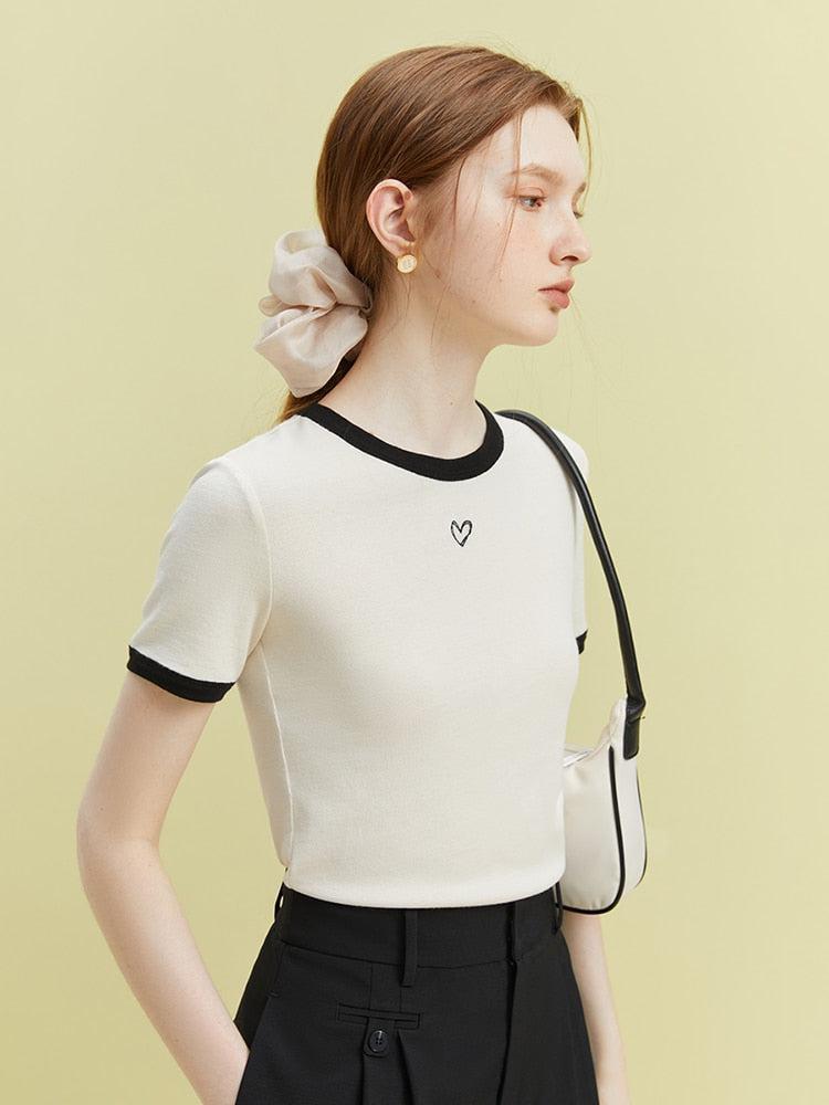 a girl is wearing a soft girl minimal heart baby tee in black and white for acubi fashion