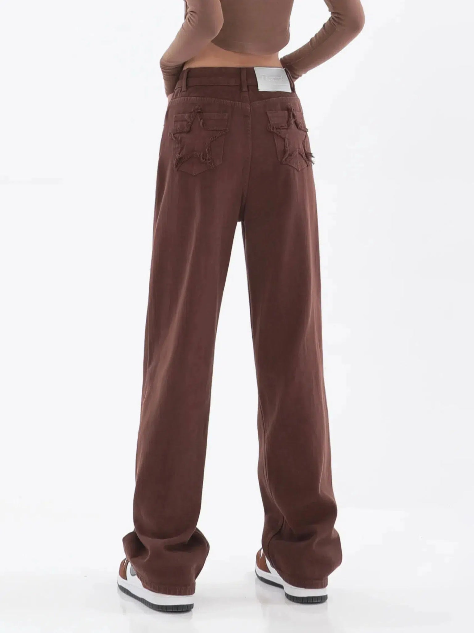 a girl is wearing star pockets wide leg jeans in brown