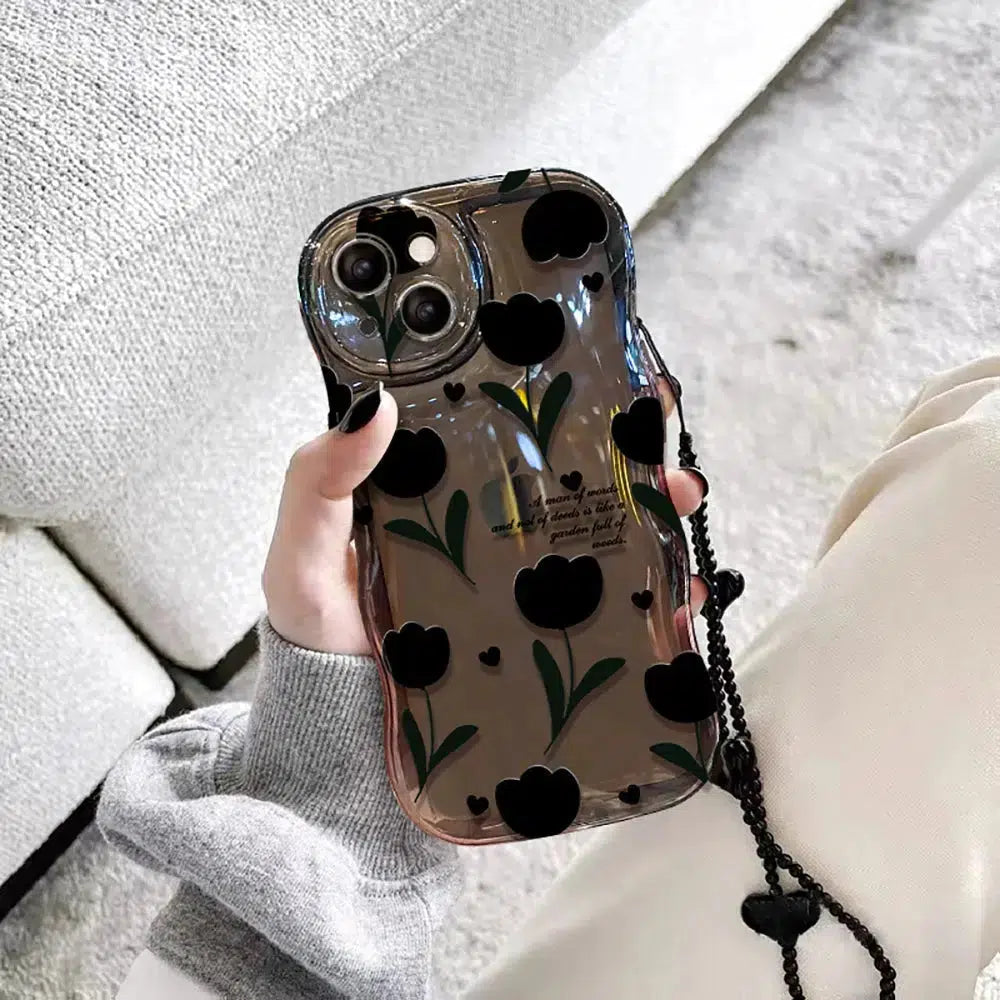 Clear phone case with bubble texture and black tulip patterns, featuring a removable heart-charm strap; a stylish, protective cover for iPhones.