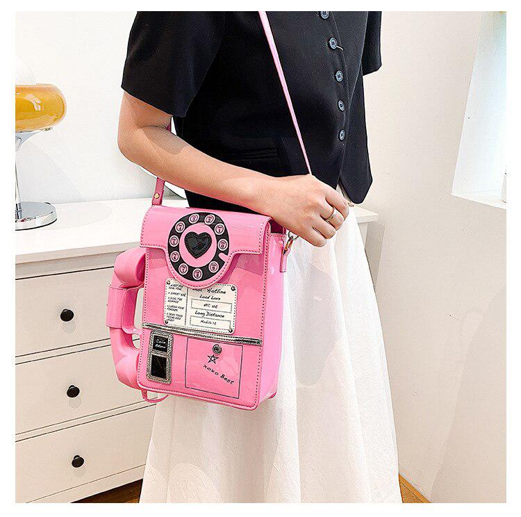 an aesthetic girl wearing a pink weirdcore retro phone shaped crossbody bag