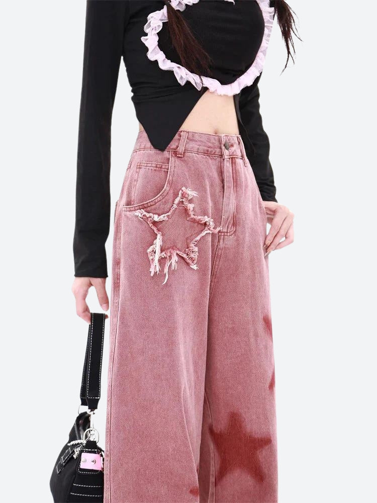 Women's Y2K star denim jeans in a wide-leg fit with embroidered and printed star details. High-waisted vintage-inspired jeans in washed pink denim, perfect for a nostalgic yet modern streetwear look